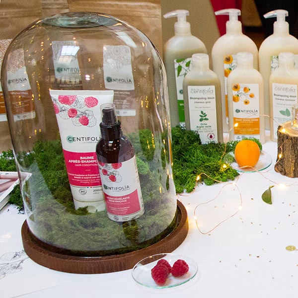 Le baume après-shampooing et la lotion démêlante à la framboise dans leur écrin de verre